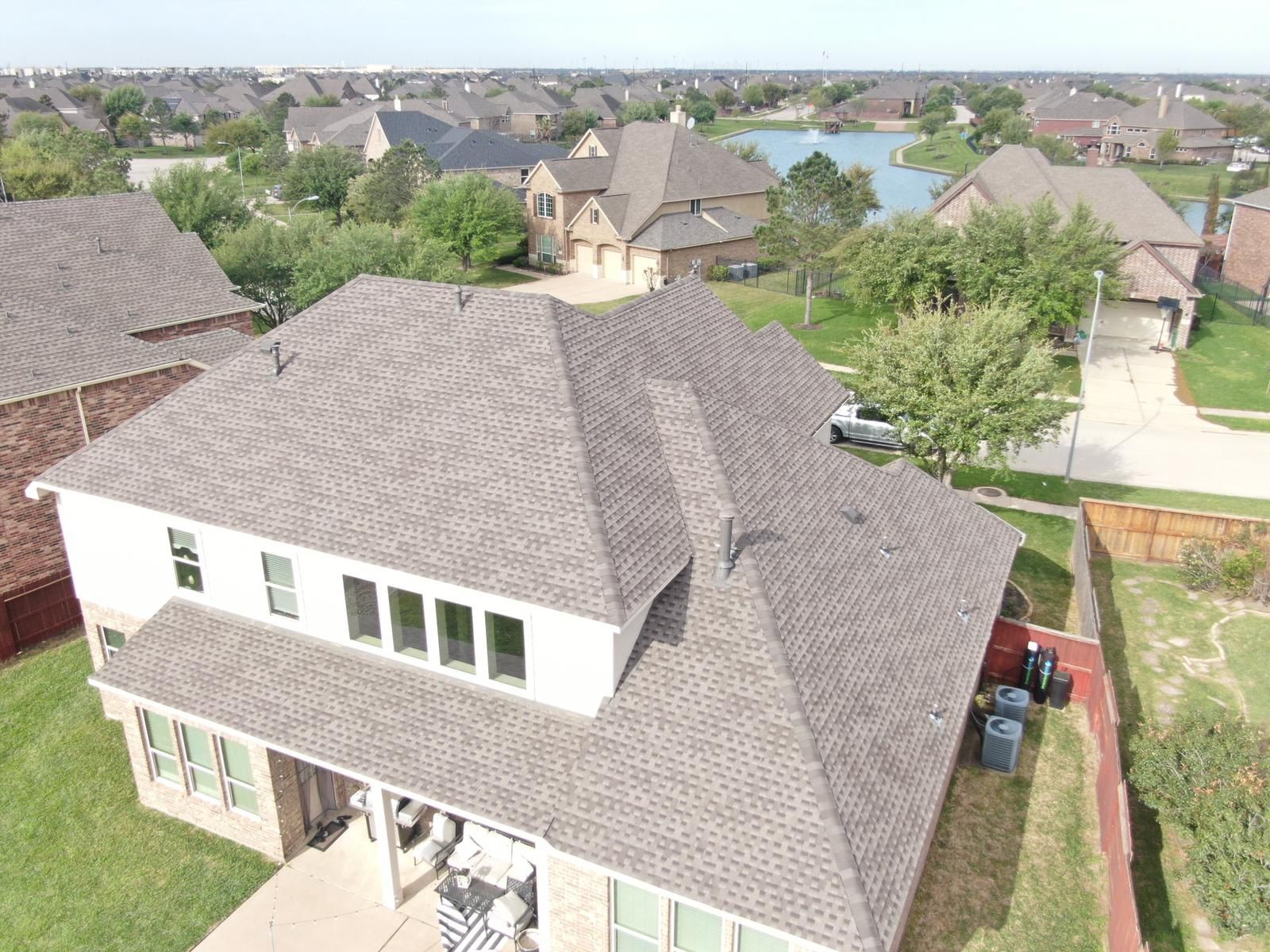 Rear aerial view of completed residential shingle roofing