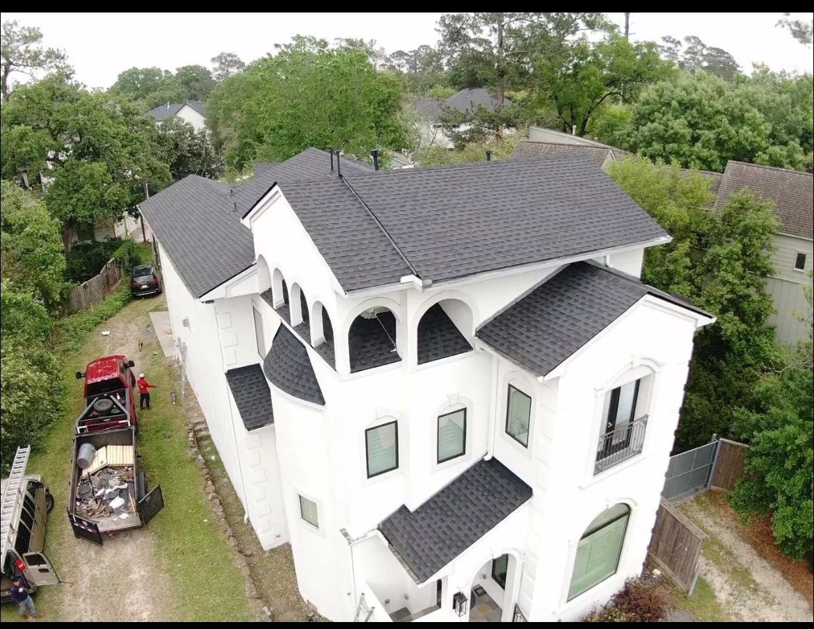 Completed charcoal shingle roof on a white residential home