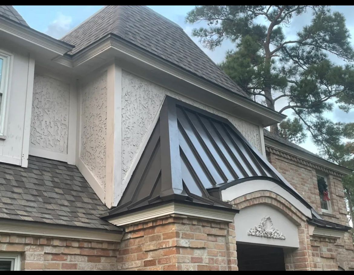Close view of a standing seam metal entryway roof and surrounding shingles