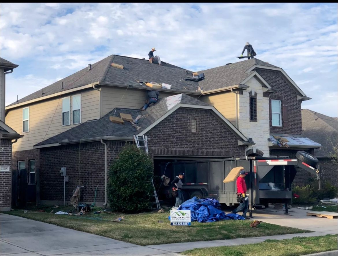 Crew installing shingles on a residential roof